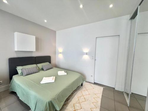 - une chambre avec un lit vert et un miroir dans l'établissement Calme & chic - Jean Jaurés - Gare Matabiau, à Toulouse