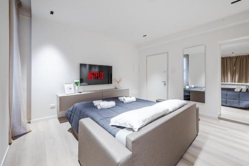 a bedroom with a bed with a tv on the wall at Vittoria Apt Luxury e Design in Duomo in Brescia