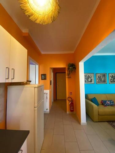 a kitchen with orange walls and a white refrigerator at Florentia Viola Apartament I in Florence