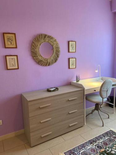 a bedroom with a dresser and a mirror on a purple wall at Florentia Viola Apartament I in Florence