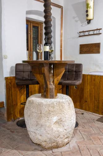 a wooden table with two chairs and a table with a mirror at Ruralna kuća za odmor Gerstmajer in Zmajevac