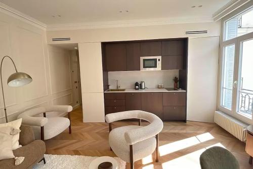Il comprend un salon avec deux chaises et une cuisine. dans l'établissement 4P 1BR - Fully Renovated with AC - Champs-Elysées, à Paris