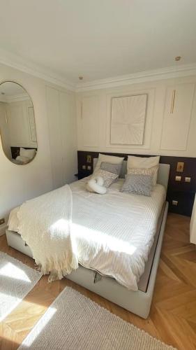 une chambre avec un grand lit blanc avec un miroir dans l'établissement 4P 1BR - Fully Renovated with AC - Champs-Elysées, à Paris