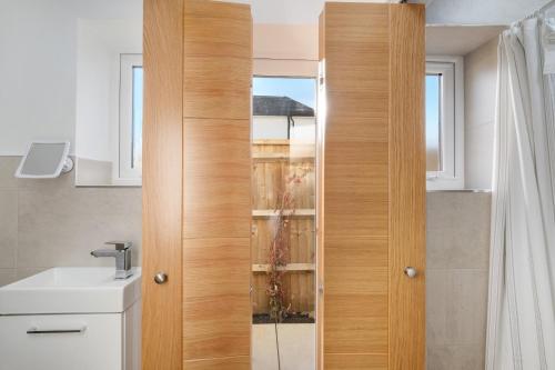 アイバーにあるBright 6 bedroom 3 bath house ideal for Pinewood Studiosのバスルーム(シンク付)の木製ドア