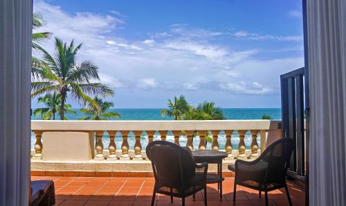 a balcony with chairs and a view of the ocean at Galle Face Hotel in Colombo