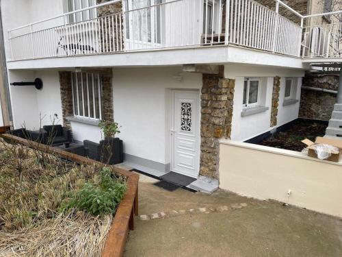 a white house with a balcony on top of it at ENTRE GUILLEMETS, Terrasse privée, 2 chambres, Parking privé, proche de Paris in Brétigny-sur-Orge