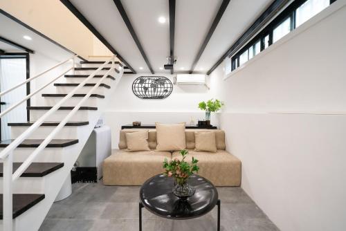 a living room with a couch and stairs at Tonight Homestay South Shanxi Road Shanghai in Shanghai