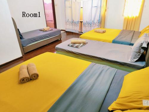 two beds in a room with yellow and blue at Area Indahpura or Taman Bersatu Kulai 3-4BR near AEON Airport JPO in Kulai