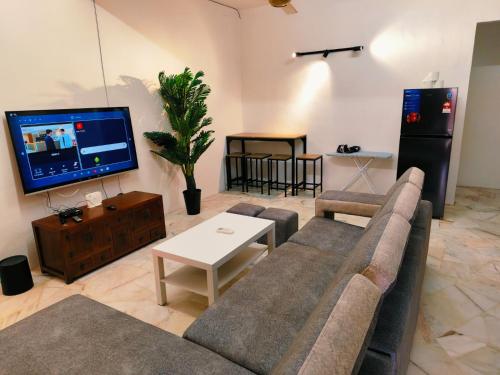 a living room with a couch and a tv at Area Indahpura or Taman Bersatu Kulai 3-4BR near AEON Airport JPO in Kulai