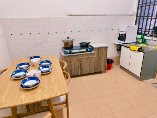 a kitchen with a table with blue and white dishes on it at Area Indahpura or Taman Bersatu Kulai 3-4BR near AEON Airport JPO in Kulai