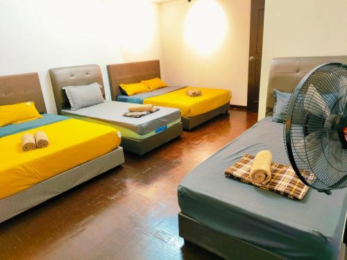 a room with four beds and a fan in it at Area Indahpura or Taman Bersatu Kulai 3-4BR near AEON Airport JPO in Kulai
