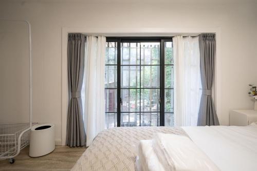 a bedroom with a bed and a large window at Tonight Homestay South Shanxi Road Shanghai in Shanghai