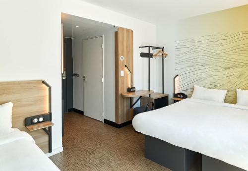 a hotel room with two beds and a desk at B&B HOTEL Champigny-sur-Marne in Champigny-sur-Marne