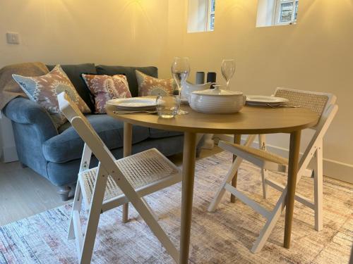 a dining room table with wine glasses and a couch at Bay House in Broadway