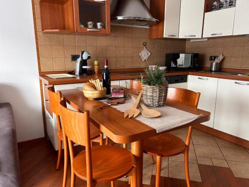 a kitchen with a wooden table with wooden chairs at Le Tre A - Sole in Folgaria