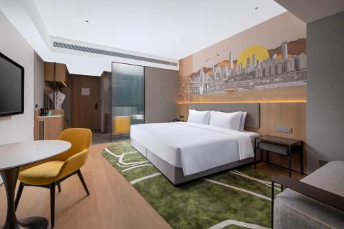 a hotel room with a white bed and a table at Holiday Inn & Suites Chongqing Nanan by IHG in Chongqing