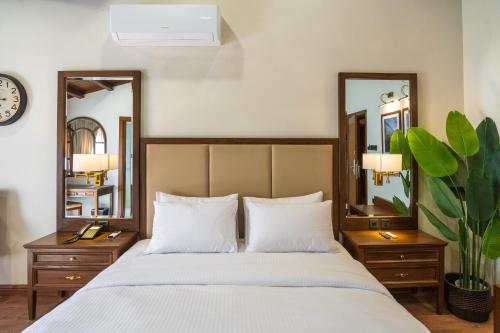 a bedroom with a large bed with two mirrors at GreenPak Hotel Hunza in Karimabad Hunza