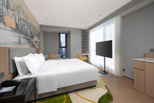 a bedroom with a large white bed and a television at Holiday Inn & Suites Chongqing Nanan by IHG in Chongqing