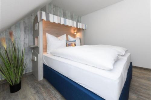 Un dormitorio con una cama grande con cabecero de madera. en Haus Strandkorb FeWo Strandkob 7, en Bensersiel