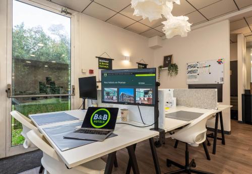 an office with a desk with a laptop on it at B&B HOTEL Brest Port du Moulin Blanc in Brest
