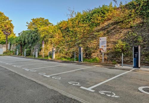 an empty parking lot next to a brick wall at B&B HOTEL Brest Port du Moulin Blanc in Brest