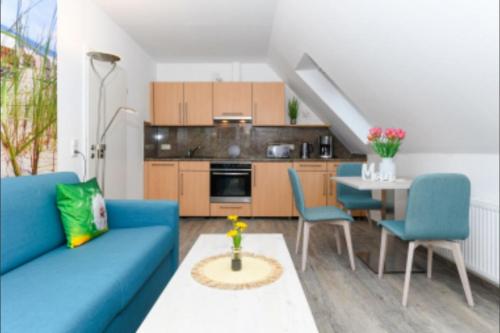 a living room with a blue couch and a table at Haus Strandkorb FeWo Strandkob 8 in Bensersiel