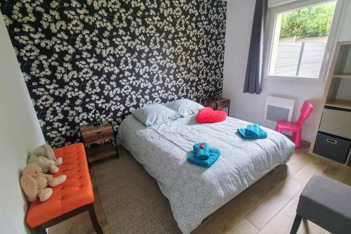 a bedroom with a bed with blue and red pillows at Ma petite maison, non accessible aux personnes à mobilité réduite in Acquigny
