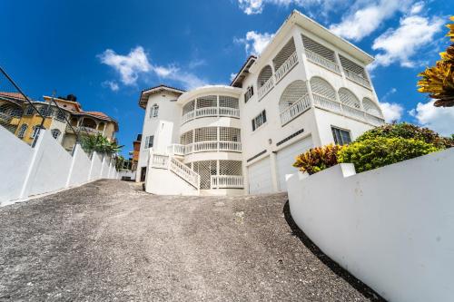 a large white house with a driveway at Skyline Suites 2 Queen bedroom - perfect for a couples getaway! condo in Montego Bay
