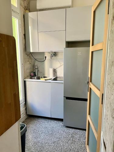  La cuisine est équipée de placards blancs et d'un réfrigérateur. dans l'établissement Studio cosy et fonctionnel en centre ville, clinique et tram à 5mn, sItuation idéale !, à Castelnau-le-Lez