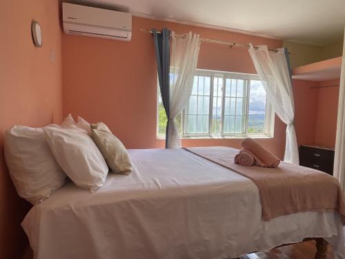 a bedroom with a white bed with a window at Skyline Suites 2 Queen bedroom - perfect for a couples getaway! condo in Montego Bay