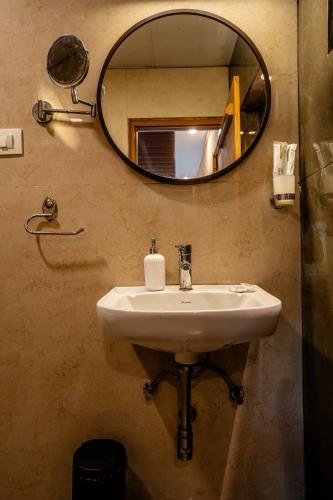 a bathroom with a sink and a mirror at Zacs Valley Resort & Wellness Retreat Kodaikanal in Kodaikānāl
