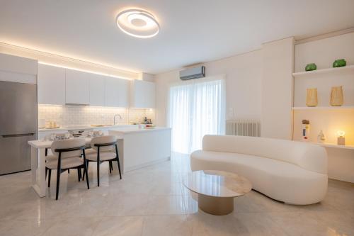 a living room with a couch and a table and a kitchen at Apeiron Athena Residences in Athens