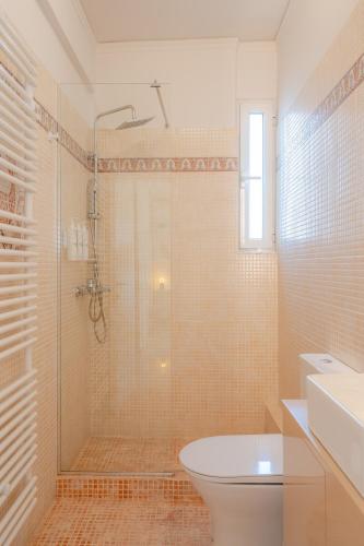 a bathroom with a shower with a toilet and a sink at Apeiron Athena Residences in Athens
