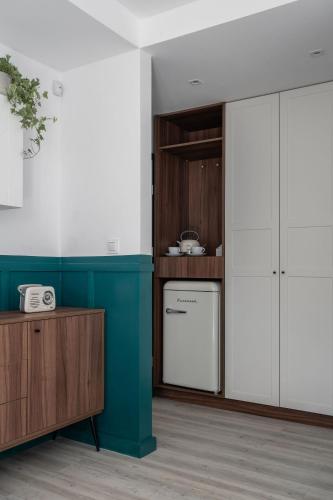 a kitchen with white cabinets and a blue wall at Pensjonat Vyspa Gdynia in Gdynia