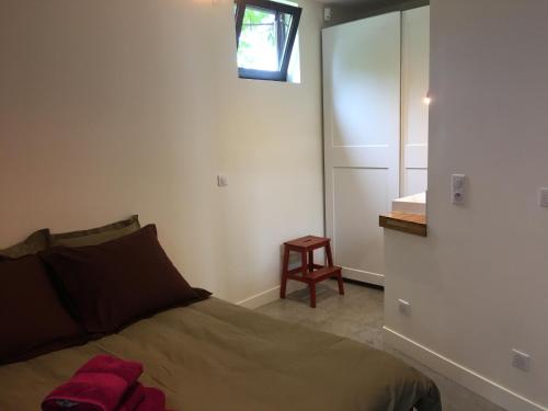 - une chambre avec un lit, une fenêtre et un tabouret dans l'établissement La petite pause, à Montreuil