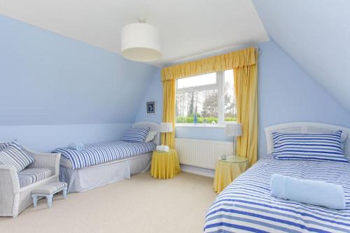 ein blaues Zimmer mit 2 Betten und einem Fenster in der Unterkunft Wildwoods - just moments from the beach! in Worth