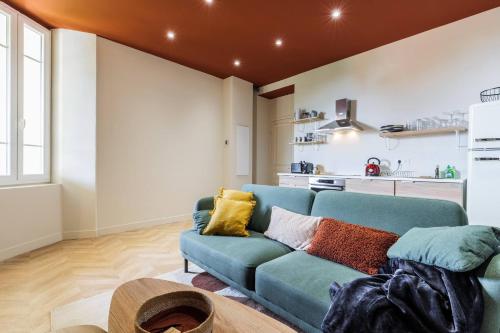 un salon avec un canapé bleu et une cuisine dans l'établissement Charmant 3 pièces vue mer, à Villefranche-sur-Mer