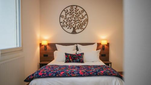 a bedroom with a bed with a tree picture on the wall at KoonTy - Chambres et Appartements à Landerneau in Landerneau
