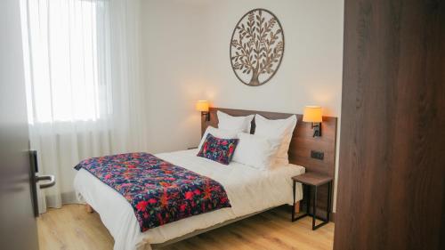a bedroom with a large bed with a colorful blanket at KoonTy - Chambres et Appartements à Landerneau in Landerneau