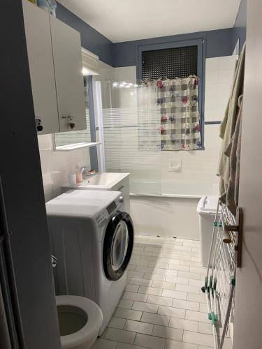 une salle de bain avec machine à laver et toilettes dans l'établissement Appartement 5 à 7 personnes à Saint François Longchamp, à Saint-François-Longchamp