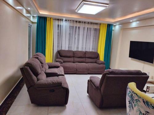 内罗毕Warm and Cosy 2 bedroom的配有两张沙发和一台平板电视的客厅
