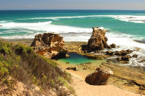 a beach with some rocks and the ocean at Rye Holiday Getaway BYO Linen and Towels 750m walk to Beach in Rye