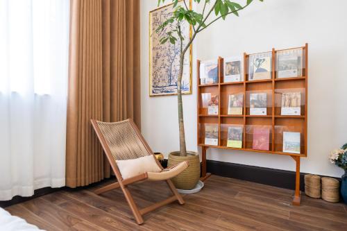 a chair in a room with a book shelf at Tonight Homestay South Shanxi Road Shanghai in Shanghai