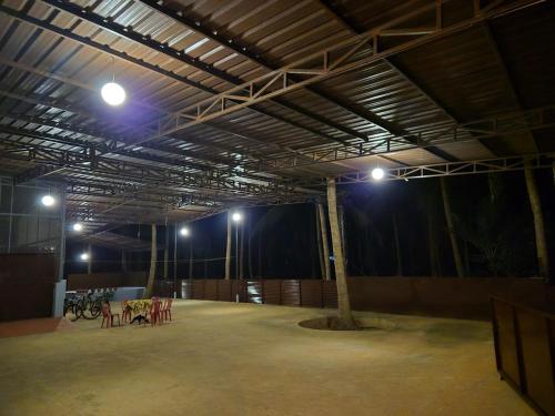 a room with tables and a tree in the middle at Stanrose Farm Stay in Kundapur