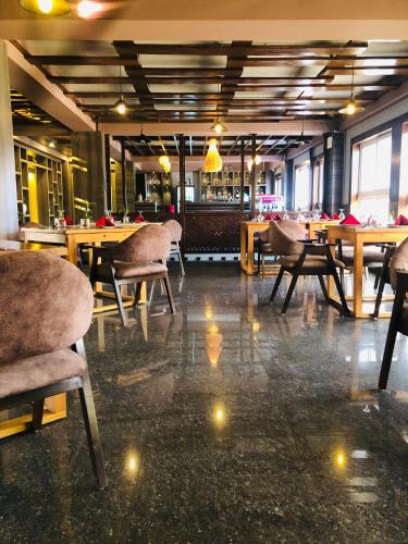 a dining room with tables and chairs in a restaurant at होटेल गोदावरी Lalitpur in Godāvari