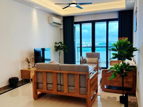 a living room with a couch and a large window at TheBess Hotel Tokyo is located adjacent to Singapore and offers a sea viewIt is a family business smart room with the sea view of Princess Bay富力公主湾 in Johor Bahru