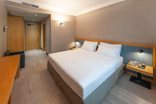 a bedroom with a large white bed and a desk at Best Western Hotel Quattrotorri in Perugia