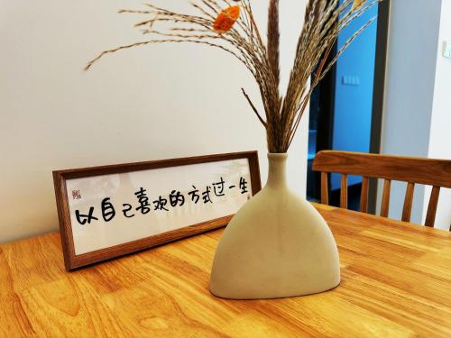 a vase sitting on a table next to a picture at TheBess Hotel Tokyo is located adjacent to Singapore and offers a sea viewIt is a family business smart room with the sea view of Princess Bay富力公主湾 in Johor Bahru