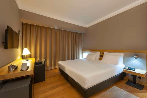 a hotel room with a large bed and a desk at Best Western Hotel Quattrotorri in Perugia