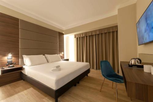 a hotel room with a bed and a desk and a television at Best Western Hotel Quattrotorri in Perugia